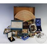 A vintage leather suitcase containing a large quantity of assorted costume and other jewellery,