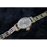 A lady's 9ct gold Tissot wristwatch, the oval silvered face with black batons,