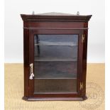 A mahogany corner cabinet, with glazed door,