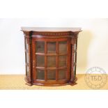 A walnut bow front wall cabinet, with bevelled glazed door,