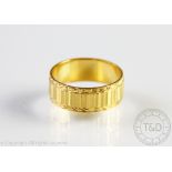 A 22ct yellow gold band, London 1964, with faceted and engraved detail, size N,