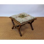 A Victorian mahogany X frame foot stool, with upholstered tapestry top and turned stretcher,