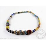 A strand of forty nine Venetian millefiori and green heart African market trading beads,
