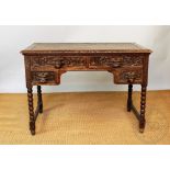 A Victorian carved oak desk, with four drawers with carved Green Man handles, on tuned legs,