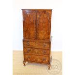 A Queen Ann style walnut cabinet, with two panelled doors,over three long drawers, on cabriole legs,