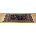 A Caucasian wool rug, worked with geometric designs against a blue ground,