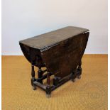A late 17th Century oak gate leg table with eight plank top on turned legs and scroll feet 73cm H x