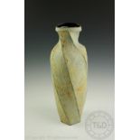 Chris Carter (British b1945) a tall studio pottery stoneware vase, of spiralling hexagonal form,