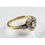 A diamond set daisy cluster ring, the central old brilliant cut diamond,