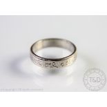 A white metal wedding band stamped 'Platinum', makers mark 'CG&S', with engraved scroll detail,