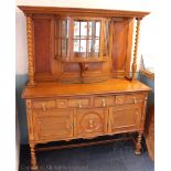 A late Victorian golden oak sideboard, with curved glass cabinet to the raised back,