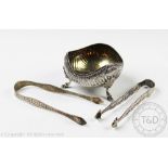 A Victorian silver sugar bowl, with embossed decoration, and serpentine rim on scroll feet,