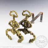 A pair of late 19th century French brass and iron fire dogs, cast with foliate scrolls,