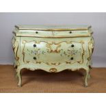 An 18th century style Italian painted commode, of bombe form with two drawers, on scroll legs,