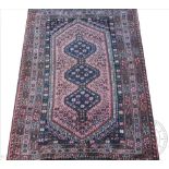 A Persian Qashqai wool rug, worked with three gulls against a red and black ground,