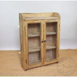 A pine hanging display cabinet, with two glazed doors,