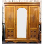 An Edwardian Arts and Crafts inlaid walnut wardrobe, with three doors,
