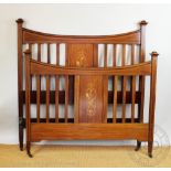 An Edwardian inlaid mahogany bed, decorated with trophies of arms. 145cm H x 141cm W x 206cm D.