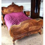A French 18th century style carved walnut bed, with serpentine head board and foot board,