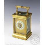 An Edwardian lacquered brass repeating brass carriage clock, with black Arabic numeral dial,