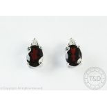 A pair of garnet and diamond set earrings in 14ct white gold,