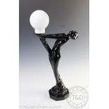 An Art Deco style figural lamp base, modelled as a nude female supporting a torch,