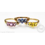 Three gem set rings, each set with three graduated pink, blue and yellow untested sapphires,