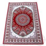A Kashmir type bamboo silk rug, worked with a circular red medallion against a white ground,