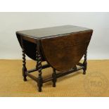 A 1920s oak gate leg table, with barley twist and block legs 74cm H x 106cm W x 55cm D.