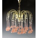 A pair of laquered brass and peach/coral coloured drop chandeliers,