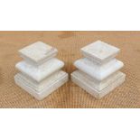 A pair of marble plinths / stands, each with faceted cushion stem raised on stepped square base,