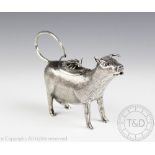 A white metal cow creamer, the beast modelled standing with textured 'fur' finish,