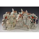 A collection of assorted Staffordshire flat back clock groups and pocket watch stands to include