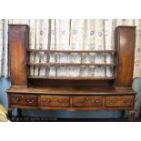 A George III Shropshire oak dresser base, the dresser base with four drawers above carved apron,