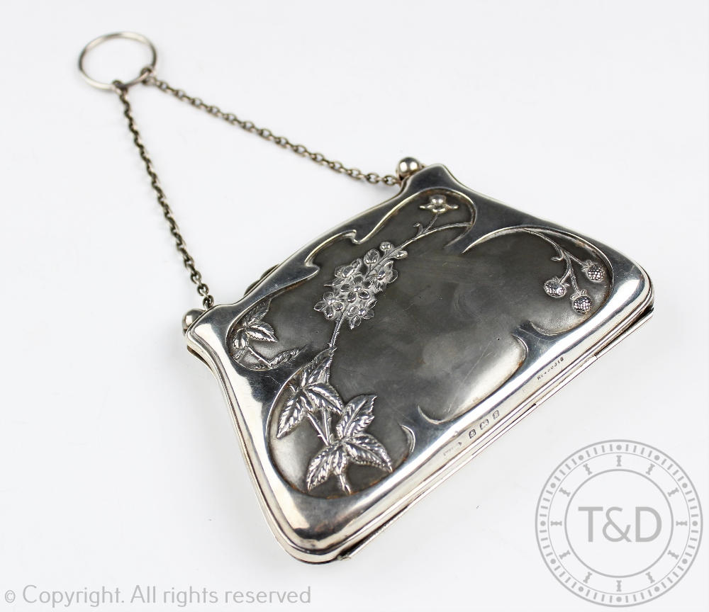 An Edwardian silver purse, of traditional form and with embossed flowering foliage design,