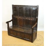 An early 18th century oak high back settle, possibly Welsh, the back with four moulded panels,