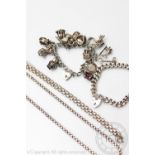 A silver charm bracelet hung with numerous charms,