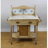 A late Victorian pine marble top washstand with tile back above a drawer and cupboard door,