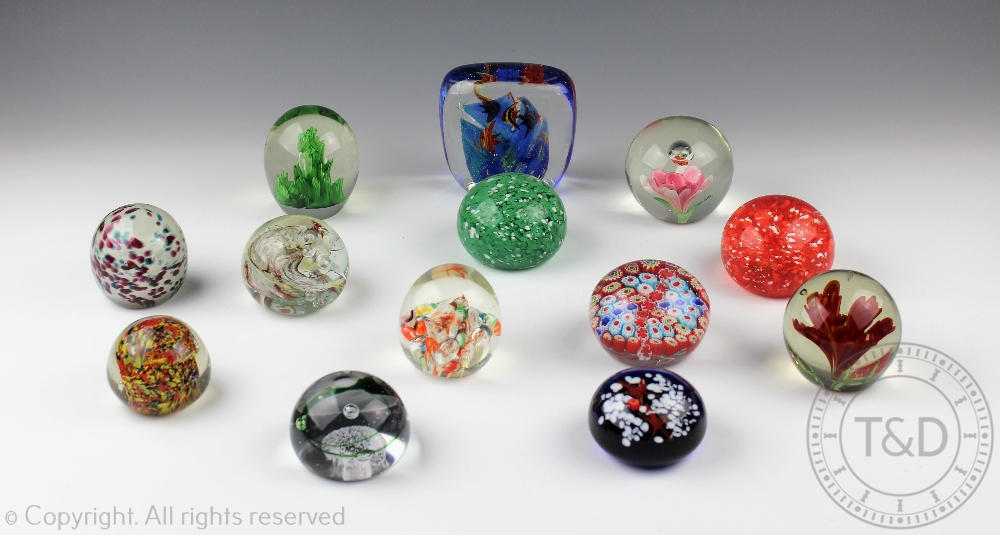 A collection of thirteen glass paperweights including a Murano style fish example,