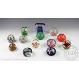 A collection of thirteen glass paperweights including a Murano style fish example,