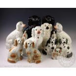 A pair of Staffordshire spaniels modelled with children, on gilt line bases, 31.