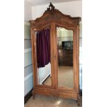 A French 18th century style carved walnut armoire, with two mirrored doors enclosing shelves,