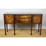 A 20th century mahogany serpentine sideboard, with two drawers flanked by two cupboard doors,