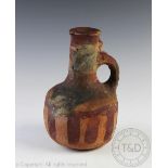 An Asiatic terracotta jug, with bulbous body and painted decoration, piriform mouth,