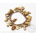 A 9ct yellow gold curb link bracelet hung with numerous charms, to include; a horse, parrot, acorn,