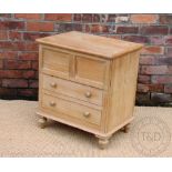 A late Victorian pine commode chest, with panelled front, on turned legs,