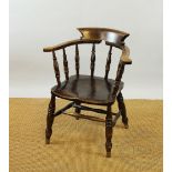 An early 20th century stained beech and ash Captains chair, with saddle seat on turned legs,