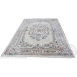 A Chinese wool carpet, worked with a floral design against an ivory ground,