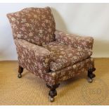 An early 20th century club type chair, with floral upholstery, on carved claw and ball feet,
