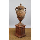 A large terracotta amphora vase and cover on plinth base, decorated with trailing vines,